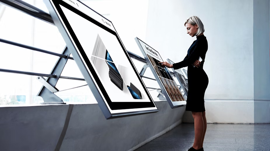 A customer interacts with a gamification kiosk at an automotive dealership